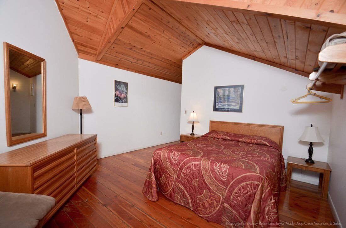 A bedroom with a king size bed and a mirror