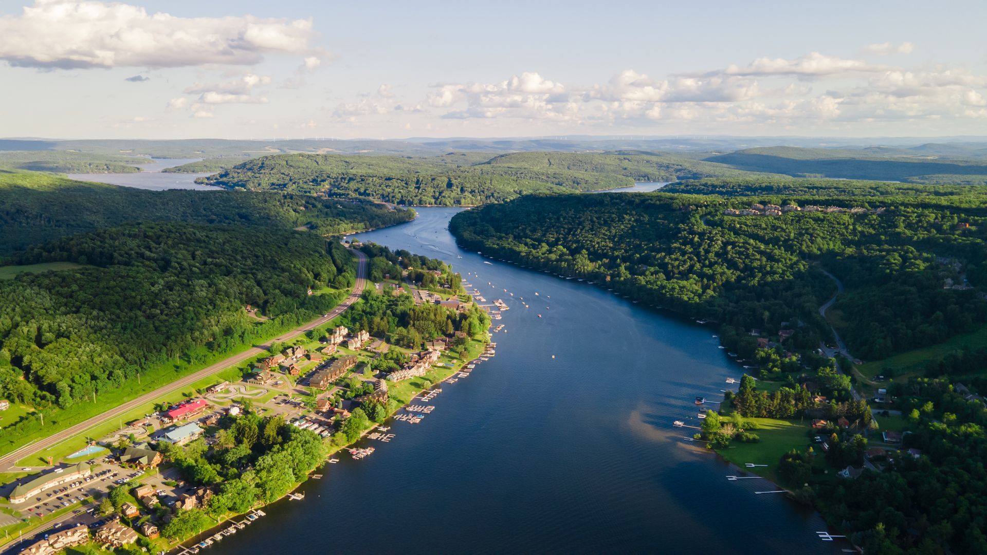 An aerial view of a river surrounded by trees and houses.