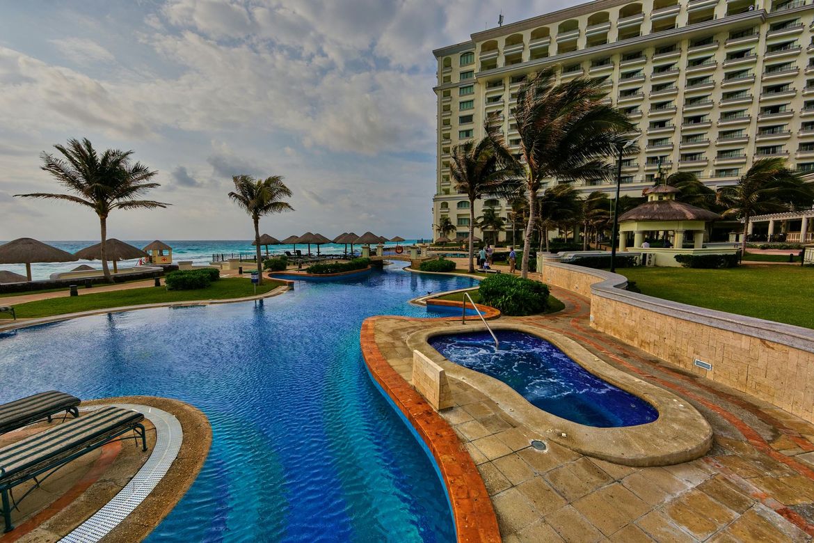 A large swimming pool with a large building in the background