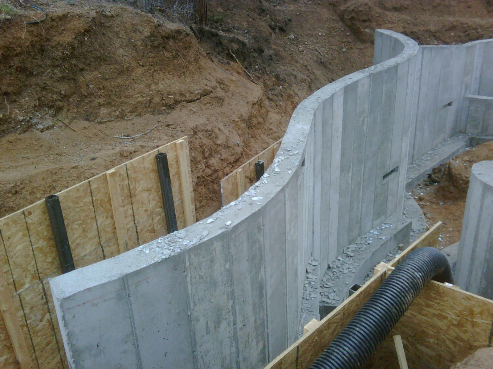 Construction site with wooden forms for a foundation, inside a trench.