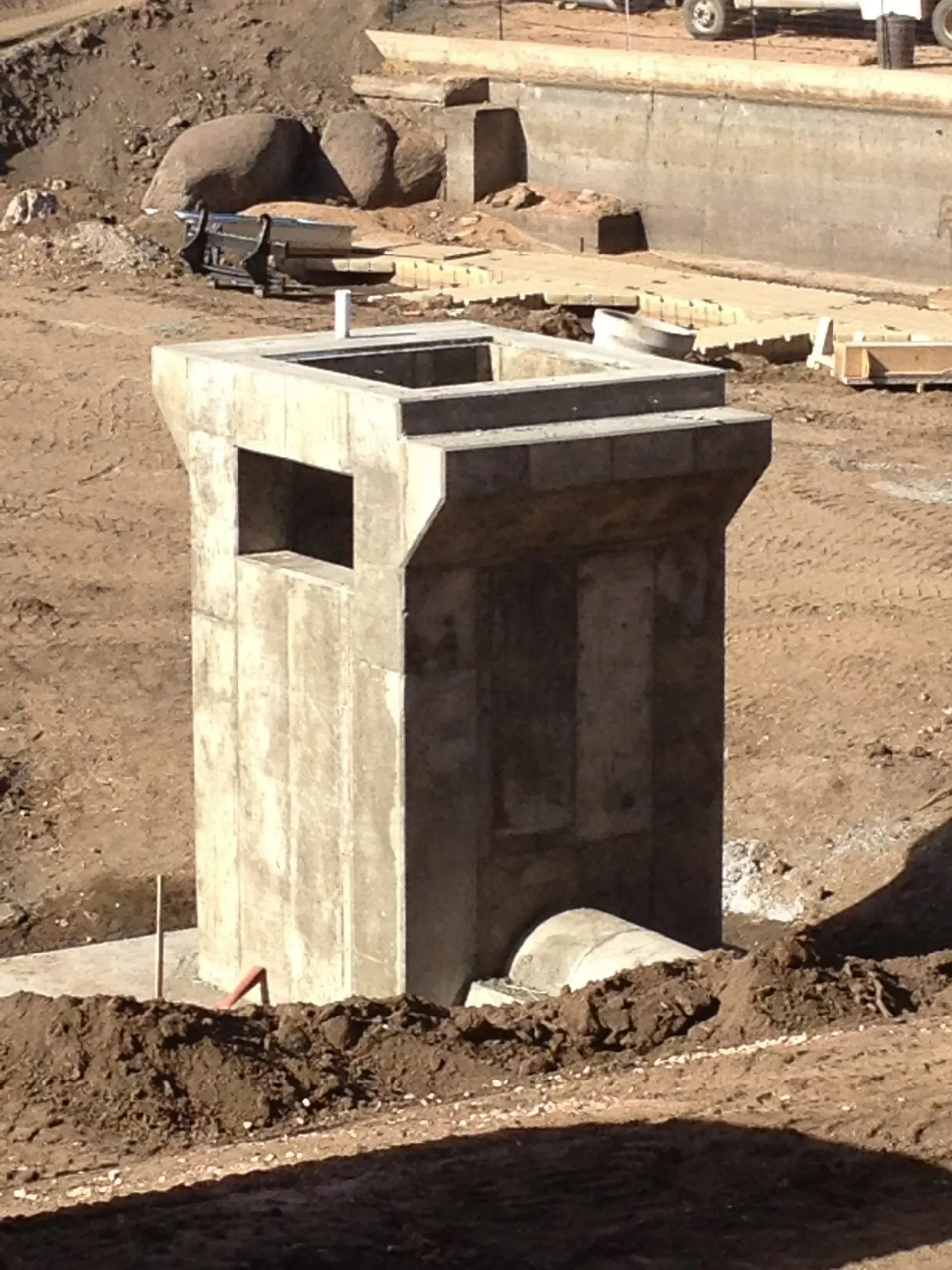 Construction site with concrete pillars, scaffolding, and dirt.