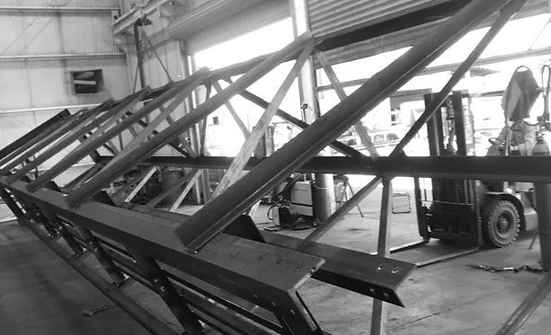 A Forklift Is Moving a Large Metal Structure in A Black and White Photo — Complete Fabrication in Townsville