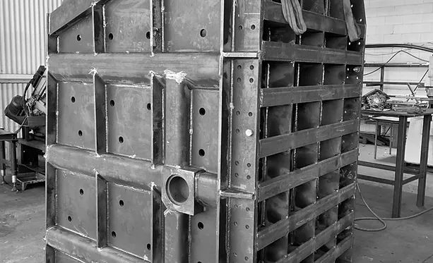 A Black and White Photo of A Large Metal Structure in A Factory — Complete Fabrication in Townsville