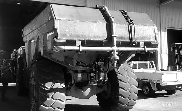 A Black and White Photo of A Dump Truck in A Garage — Complete Fabrication in Townsville