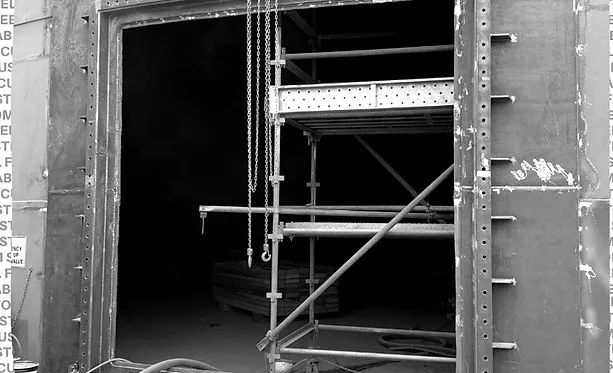 A Black and White Photo of A Building Under Construction with Scaffolding — Complete Fabrication in Townsville