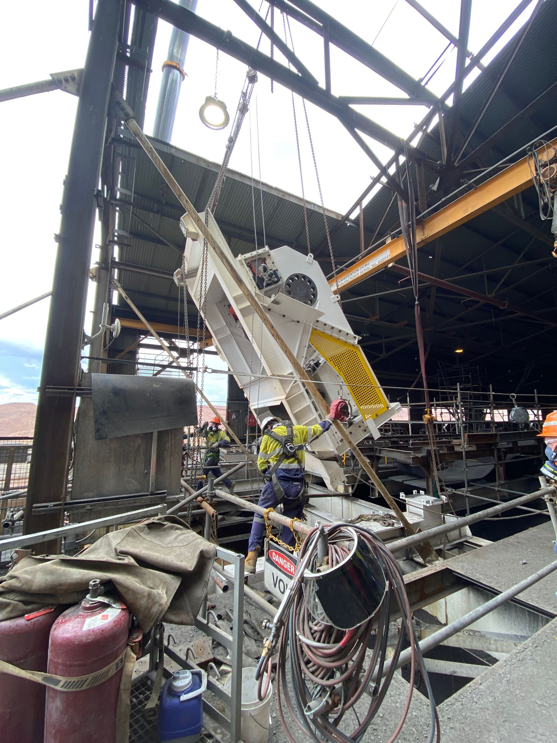 A Large Piece Of Equipment Is Being Lifted By A Crane In A Building — Custom Steel Fab in Garbutt, QLD