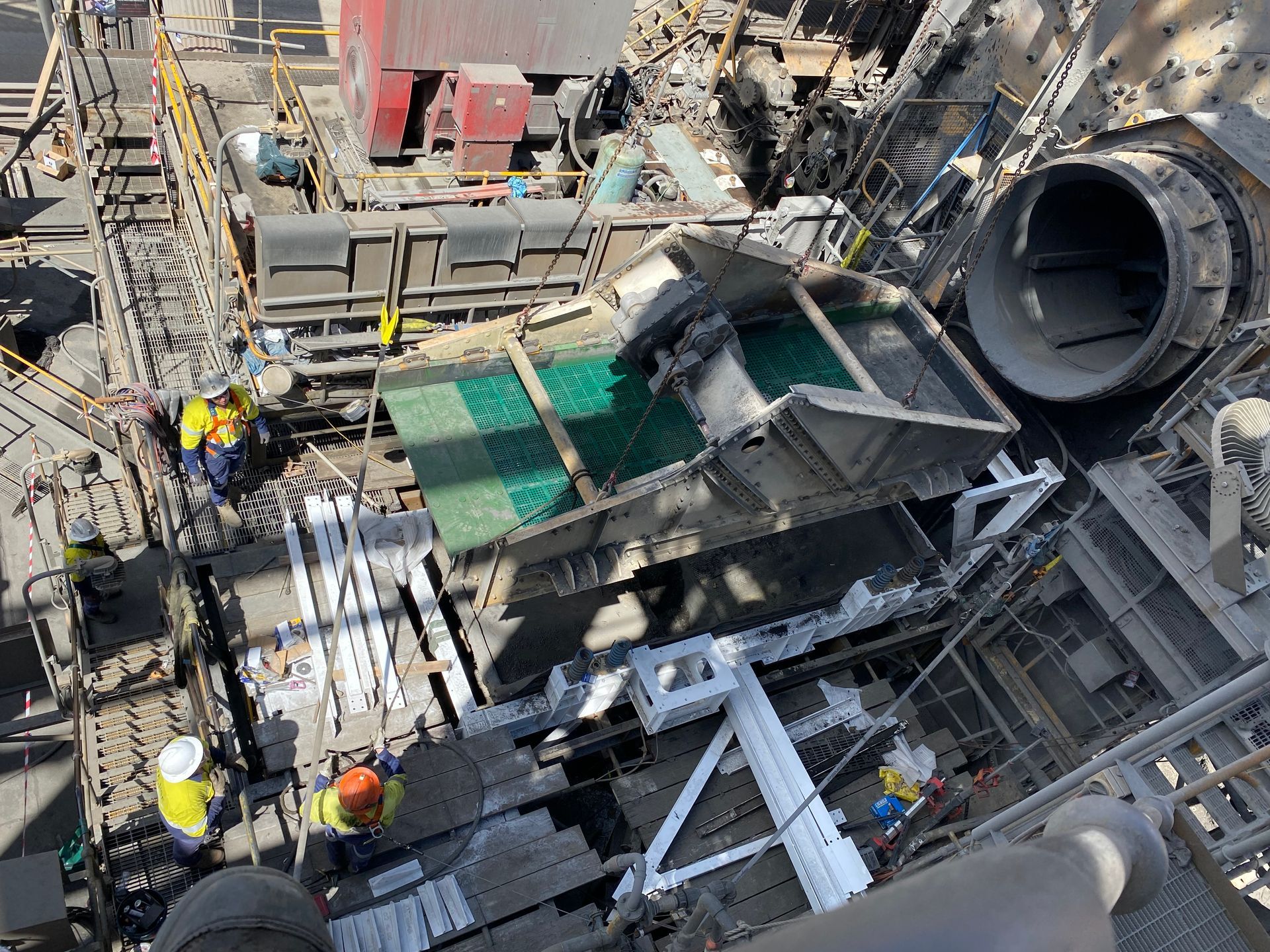 A Group Of People Are Working On A Large Machine In A Factory — Custom Steel Fab in Garbutt, QLD