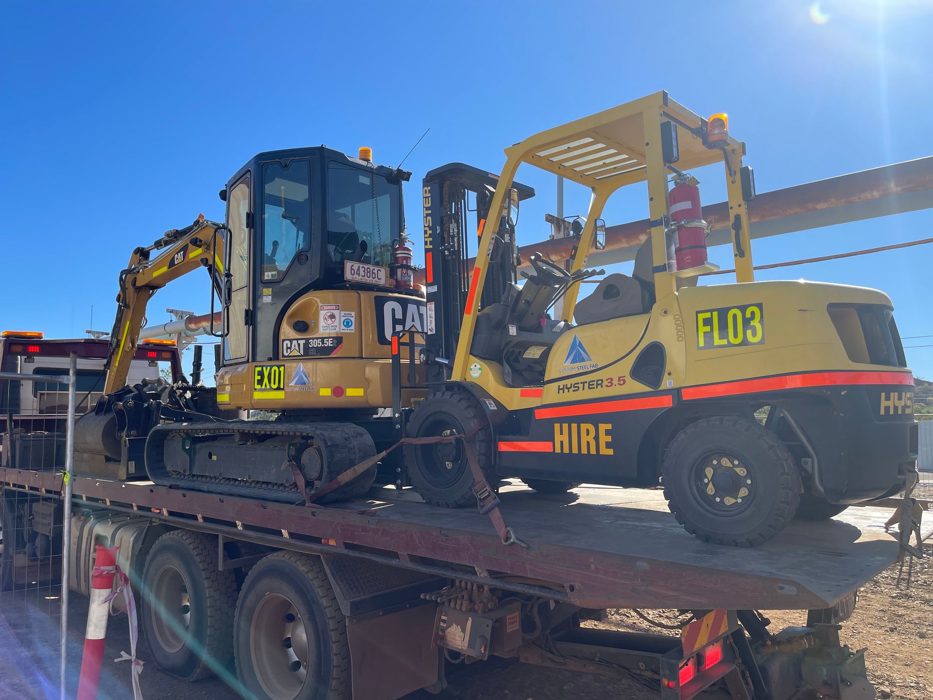 A Forklift And Excavator Are Sitting On Top Of A Flatbed Truck — Custom Steel Fab in Garbutt, QLD