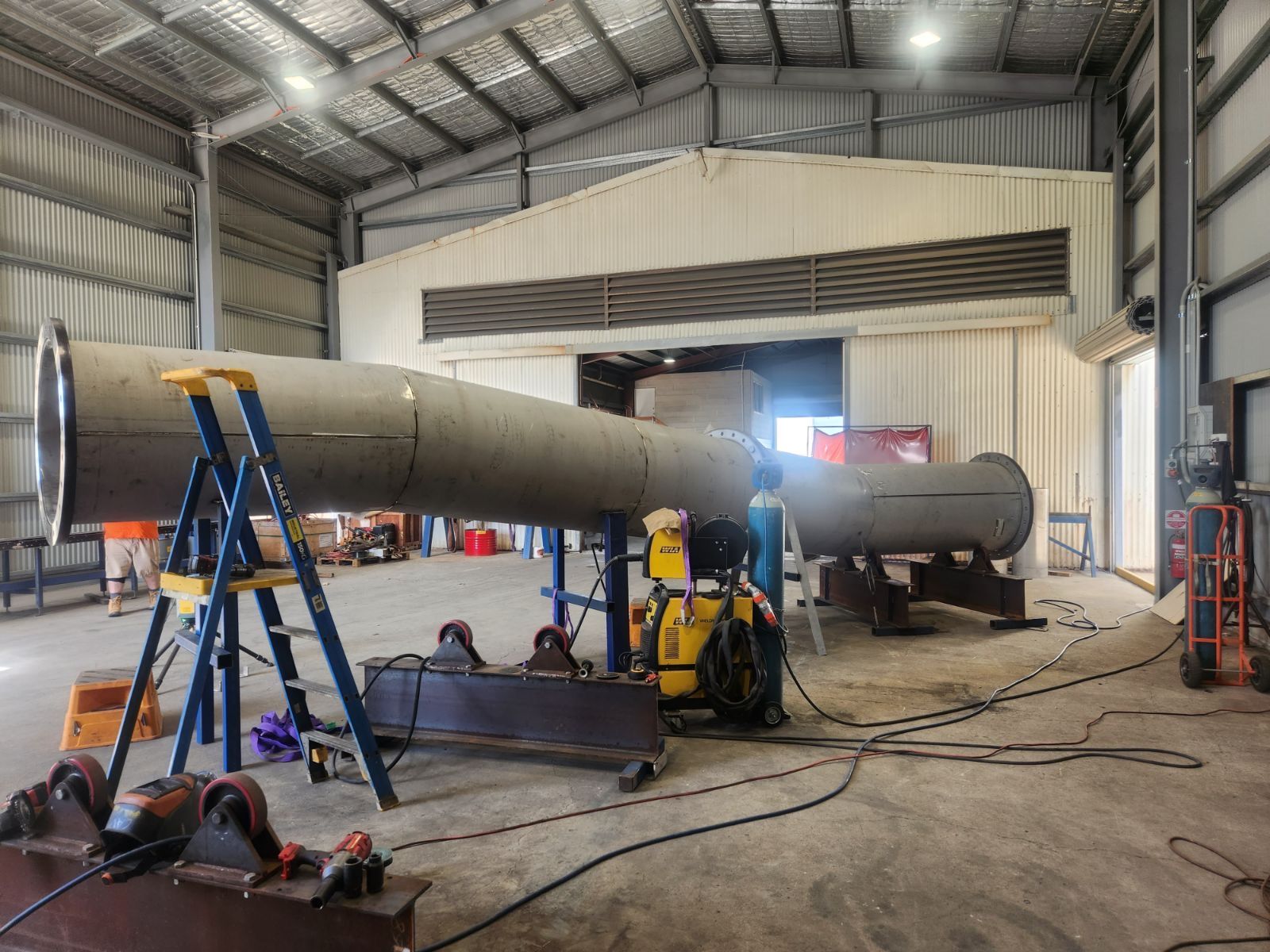 A large pipe is being built in a factory.