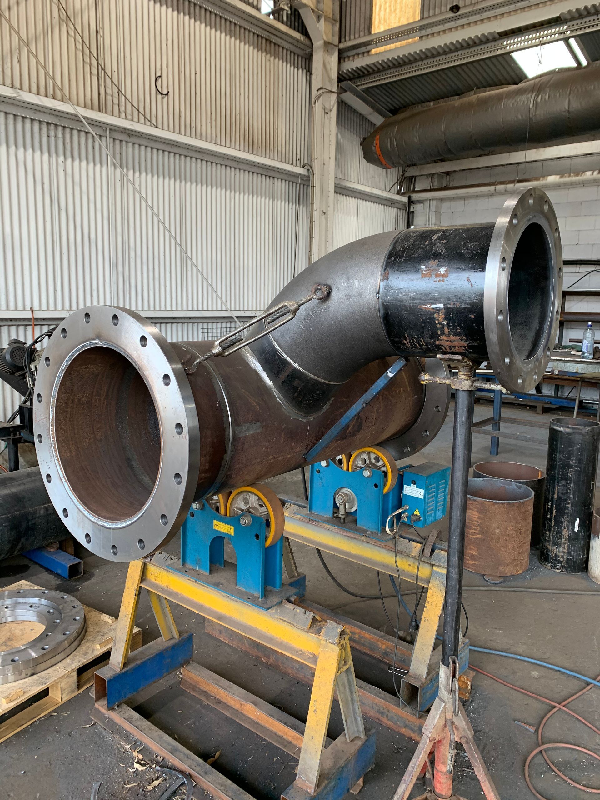 A Large Pipe Is Sitting On A Table In A Factory — Custom Steel Fab in Ravenswood, QLD