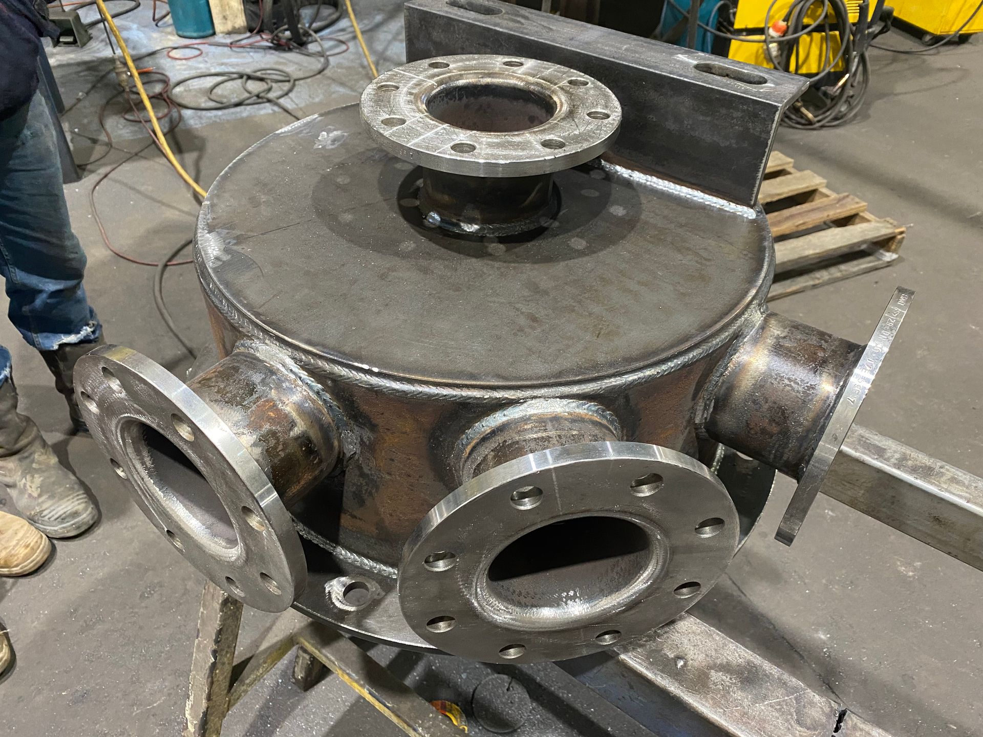 A person is working on a piece of metal in a factory.