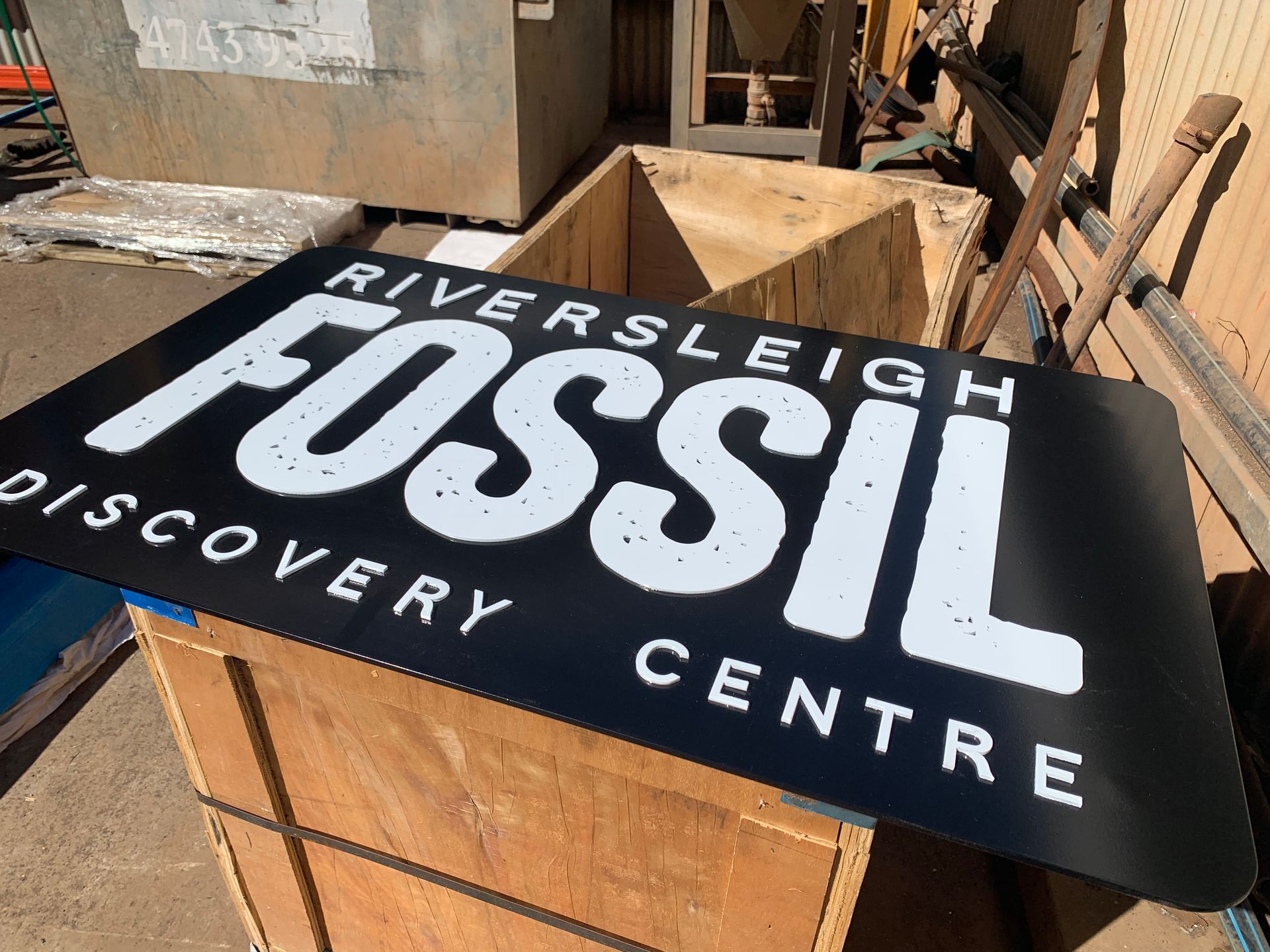 A riverleigh fossil discovery centre sign is sitting on top of a wooden box