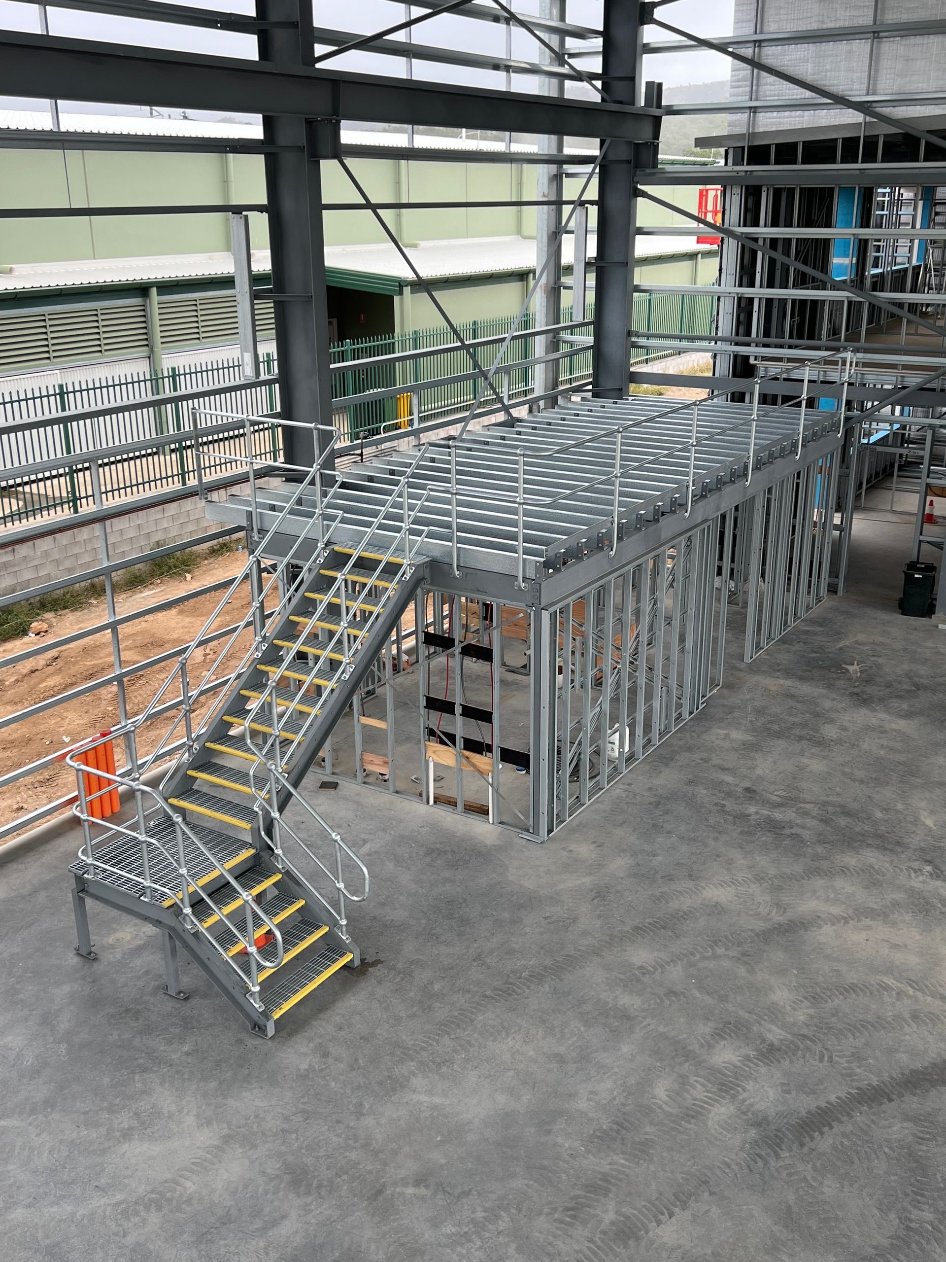 A Metal Platform With Stairs Leading Up To It In A Building — Custom Steel Fab in Garbutt, QLD