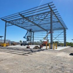 A Large Metal Structure Is Being Built In A Gravel Lot — Custom Steel Fab in Garbutt, QLD