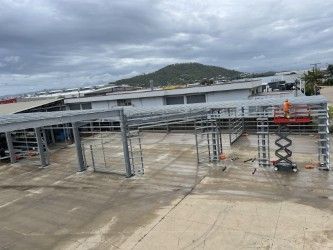 A large metal structure is being built on the roof of a building.