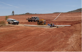 A truck is parked in the middle of a dirt field.