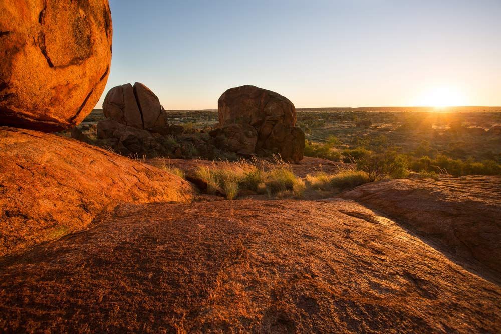 The Sun Is Setting Behind A Large Rock In The Desert — Custom Steel Fab in Tennant Creek, NT