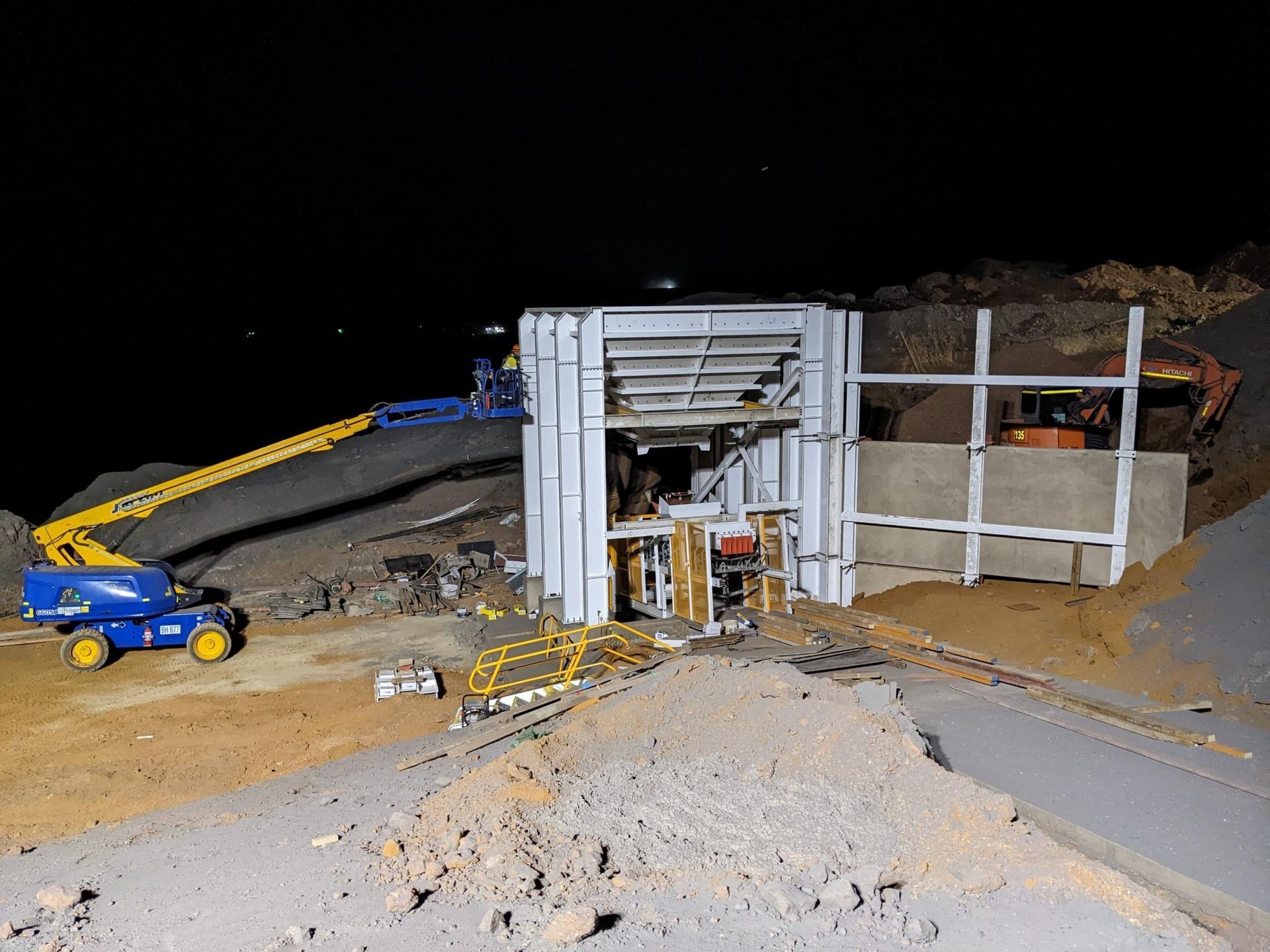 A Construction Site At Night With A Crane And A Truck — Custom Steel Fab in Garbutt, QLD