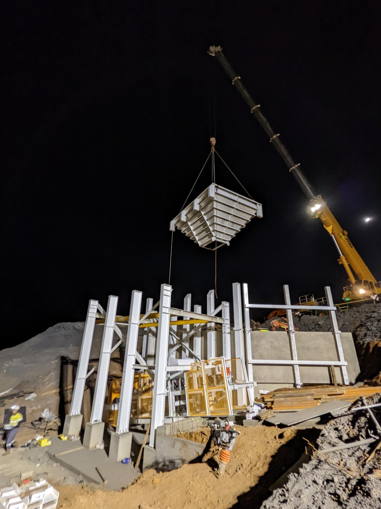 A Large Crane Is Lifting A Large Piece Of Metal Into The Air — Custom Steel Fab in Garbutt, QLD