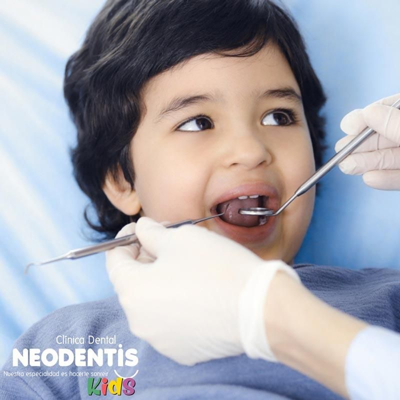 Un dentista examina los dientes de un niño pequeño