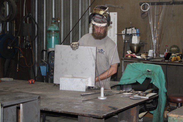 Man Aligning The Metal — Olivia, NC — Olivia Machine & Tool, Inc