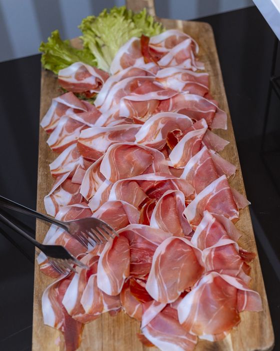 Un tagliere di legno pieno di carne e lattuga