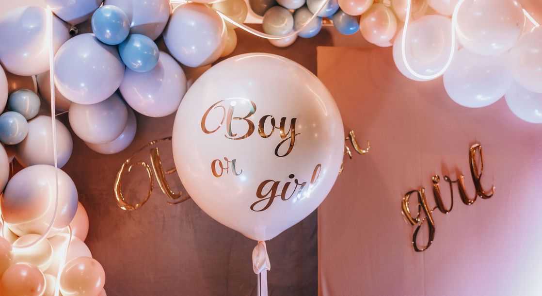 Una decorazione per baby shower con palloncini e un palloncino con la scritta ``maschio o femmina''.
