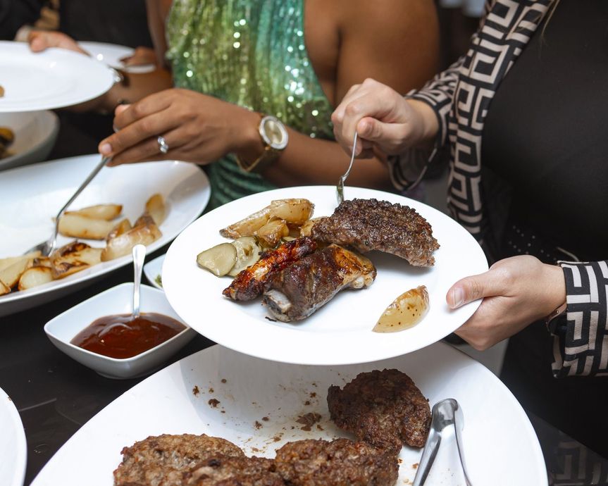 Una donna tiene in mano un piatto di cibo con sopra della carne
