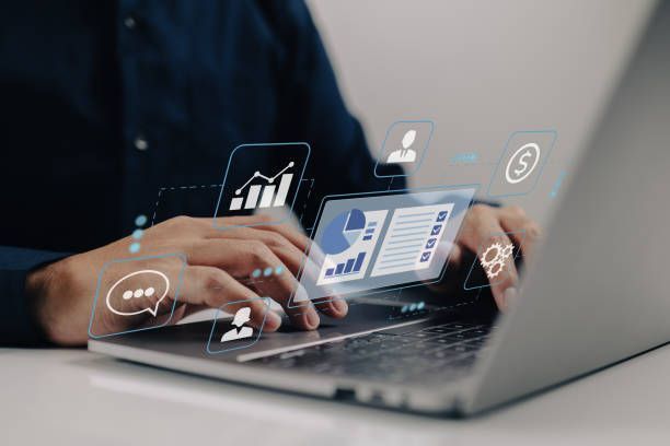 A Woman Wearing Headphones Is Sitting at A Desk in Front of A Computer.