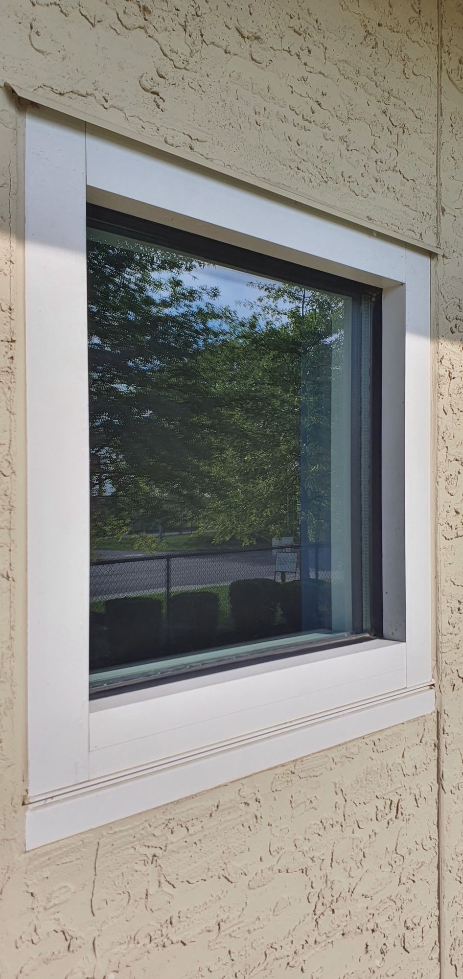 A square window on the side of a building with a white frame.