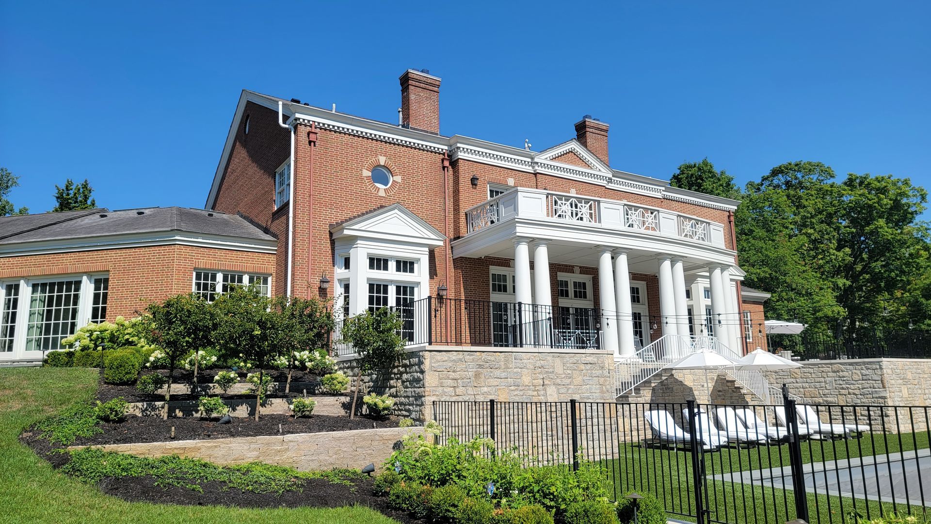 A large brick house with a fence in front of it