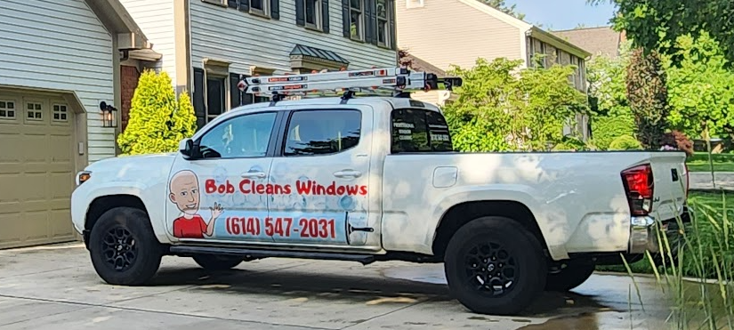 A white truck is parked in front of a house.