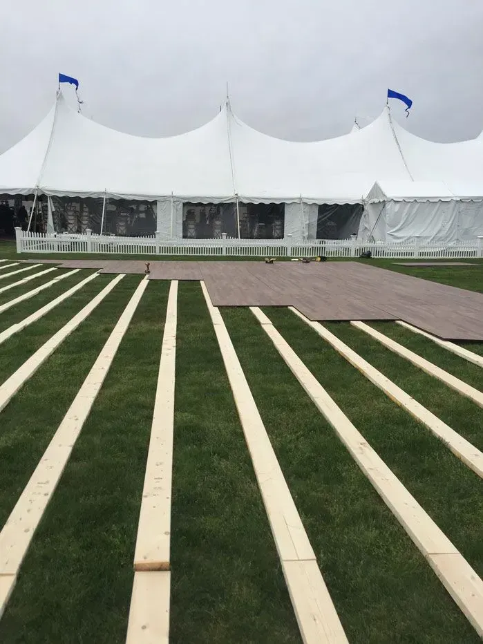 A stainless steel commercial food service rolling rack with multiple tray slots on four wheels against a white background.