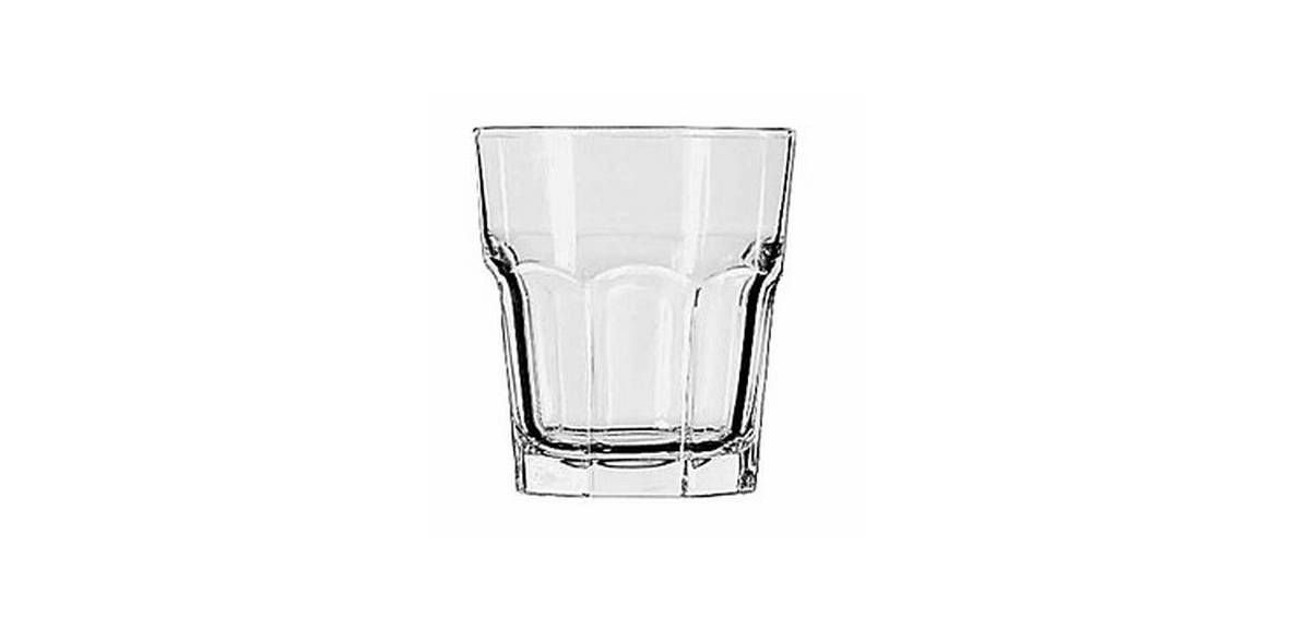 A clear, heavy-bottomed glass tumbler with vertical panel detailing on the sides.