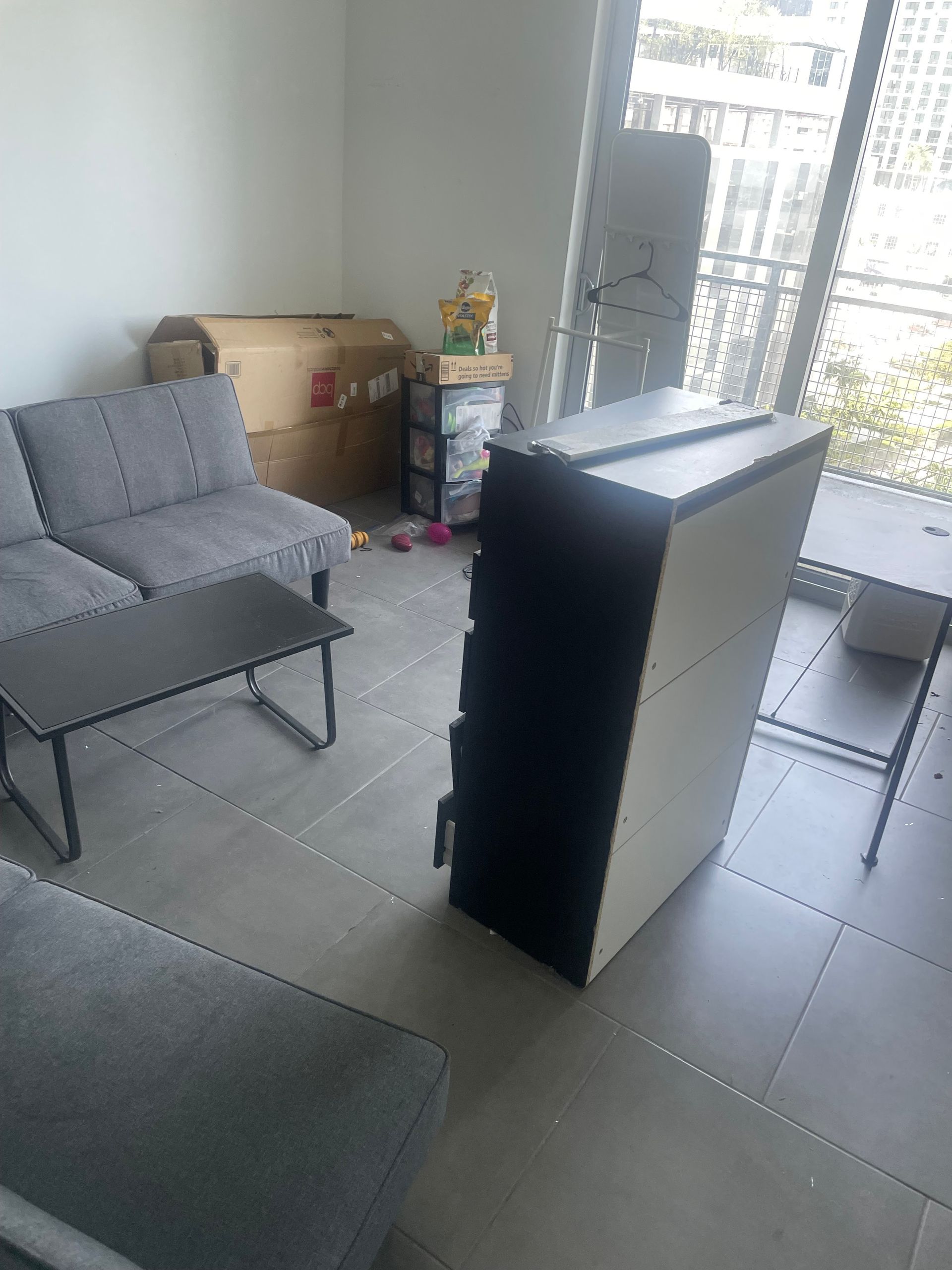A living room with a couch , chair , coffee table and dresser.
