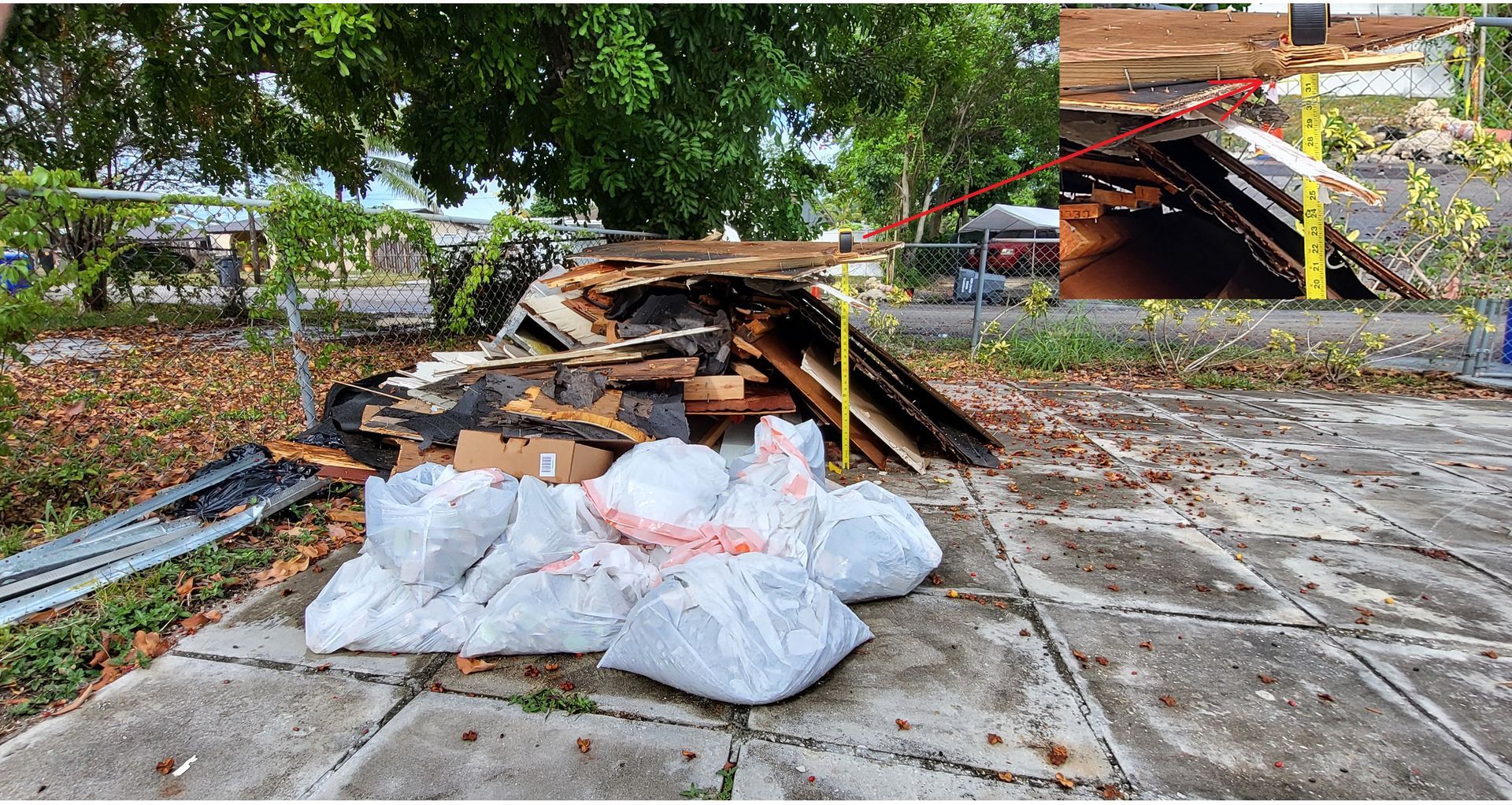 A pile of trash is sitting on a sidewalk next to a tree.