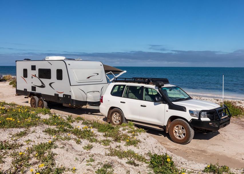 Four Wheel Drive Towing Caravan Along Beach — Caravan Experts In The Charters Towers Region, QLD