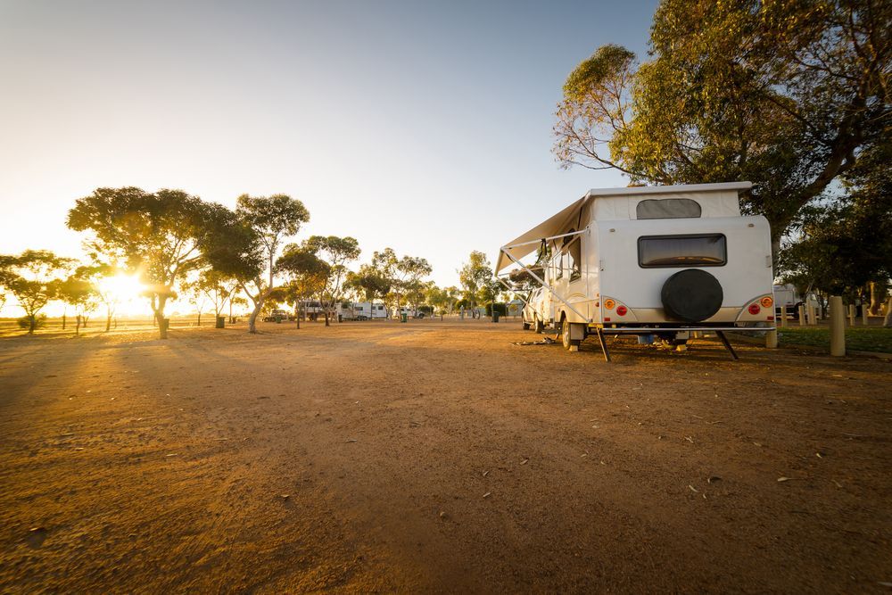 Caravan Parked at Dirt Caravan Site at Sunset — Caravan Experts In The Charters Towers Region, QLD