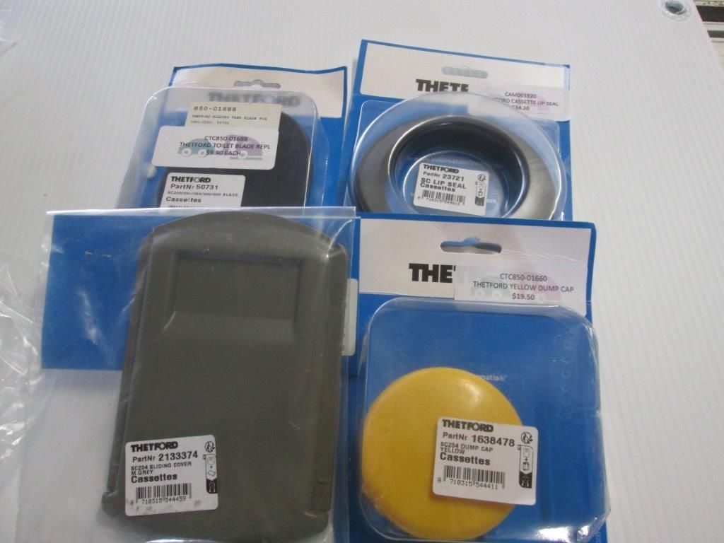 Four Packaged Auto Parts On A White Surface, Varying Shapes And Colors — Caravan Experts In The Charters Towers Region, QLD
