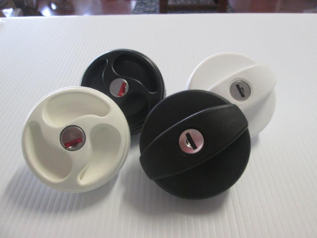 Four Black And White Fuel Tank Caps On A White, Textured Surface — Caravan Experts In The Charters Towers Region, QLD