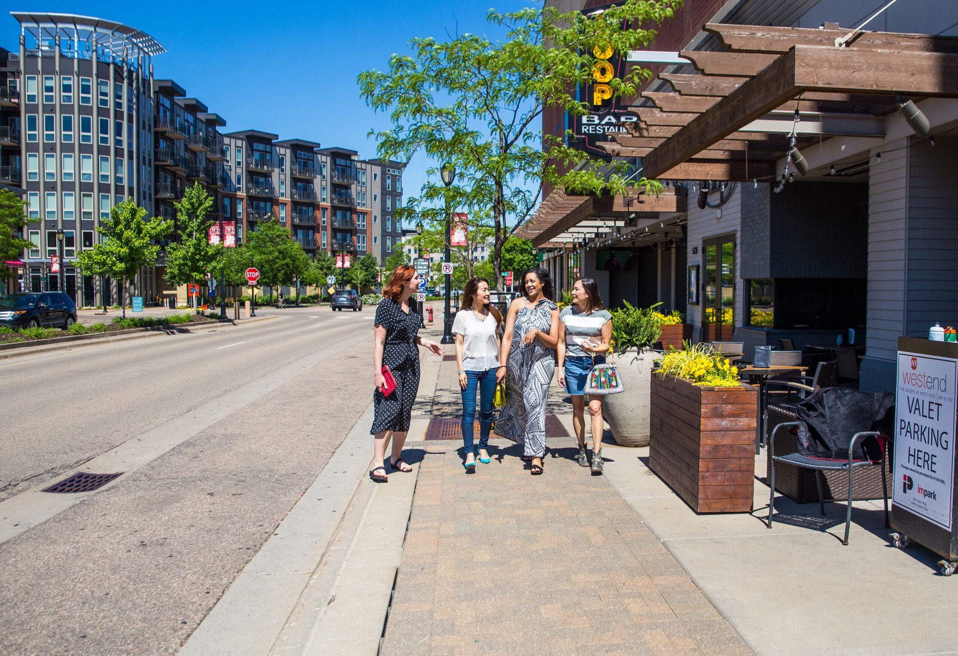 a group of people are walking down a sidewalk in front of a building .