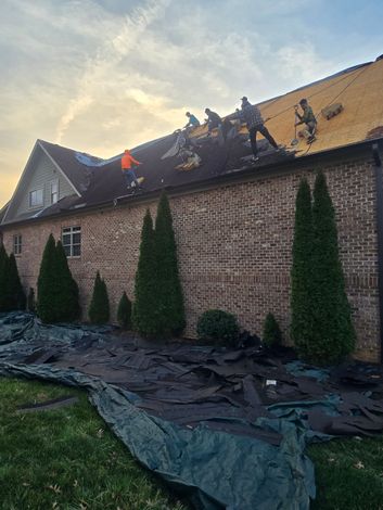 Damaged red-tiled roof with a long exposed repair section and missing tiles