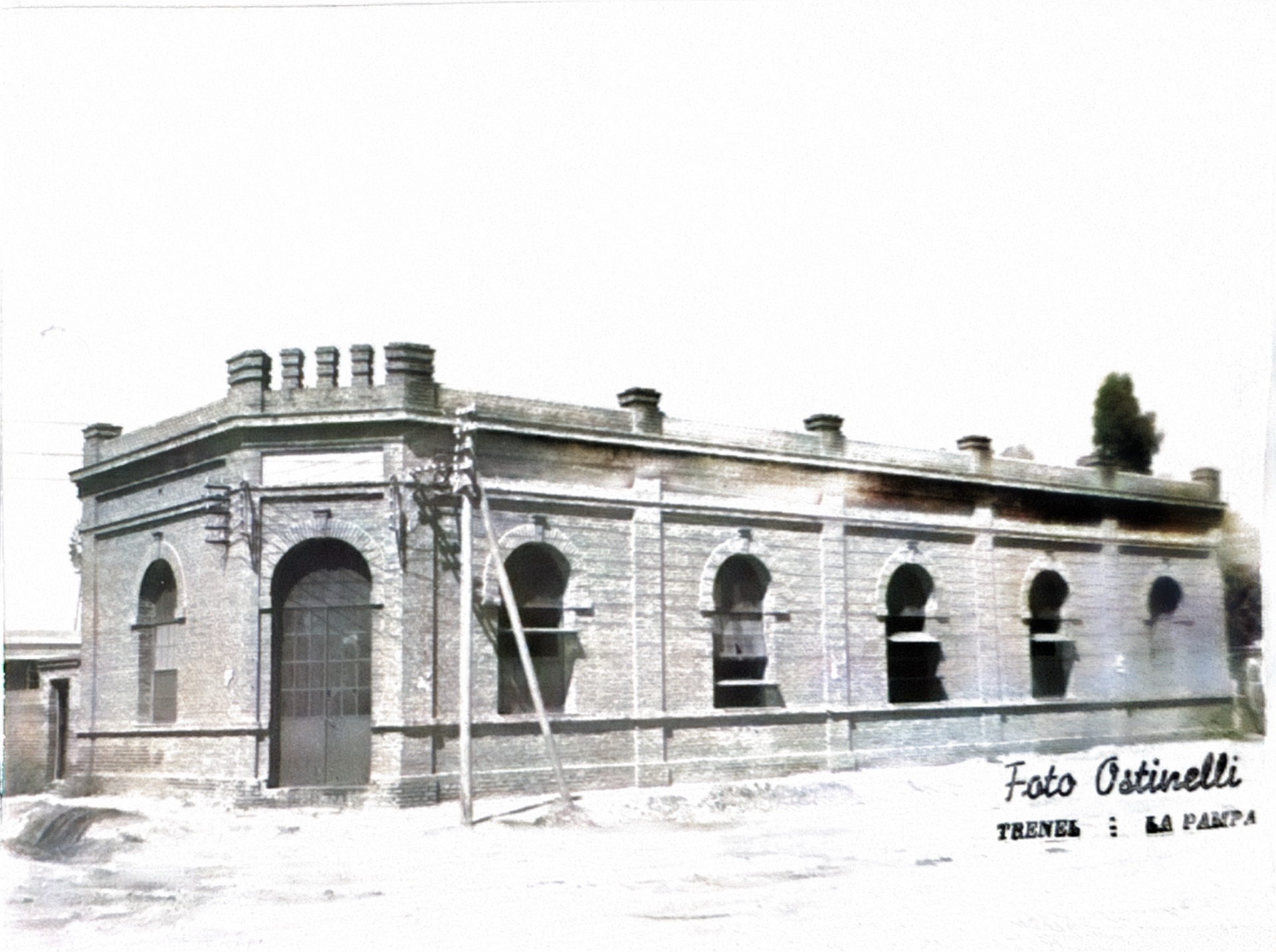 Antiguo edificio de ladrillo con ventanas arqueadas, posiblemente una estación de tren. Se ven