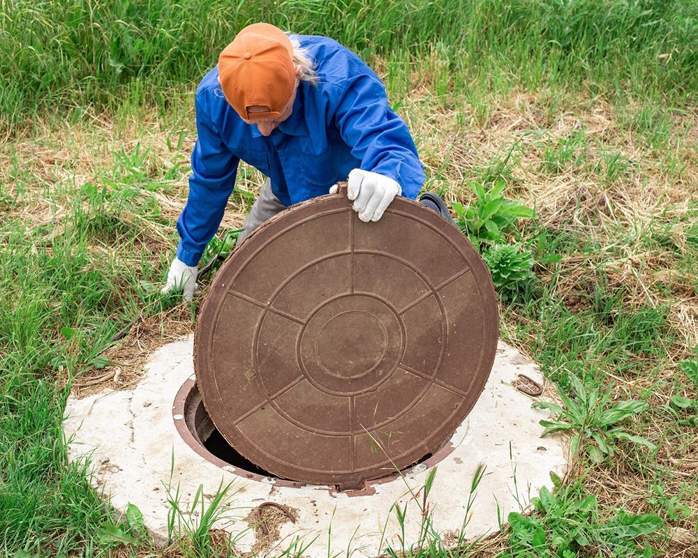 A worker from Autry’s Backhoe & Septic Service performing a septic system inspection in Concord, NC.