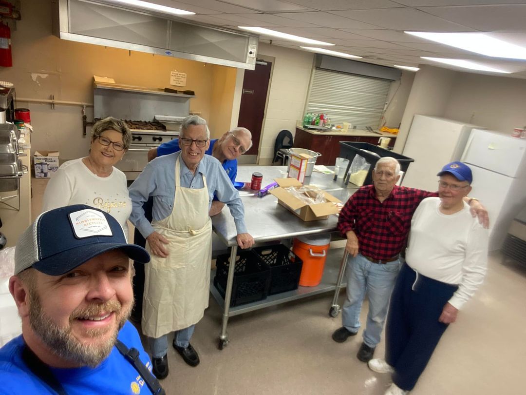A group of people are posing for a picture in a kitchen.