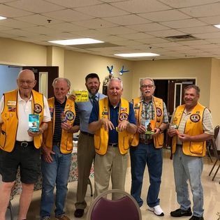 A group of men wearing yellow vests are posing for a picture.
