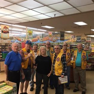 A group of people are posing for a picture in a grocery store.