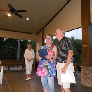 A man and a woman standing under a ceiling fan