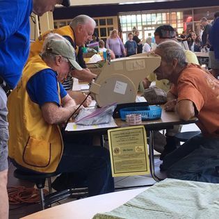 A group of men are sitting around a table with a sign that says ' lsu ' on it