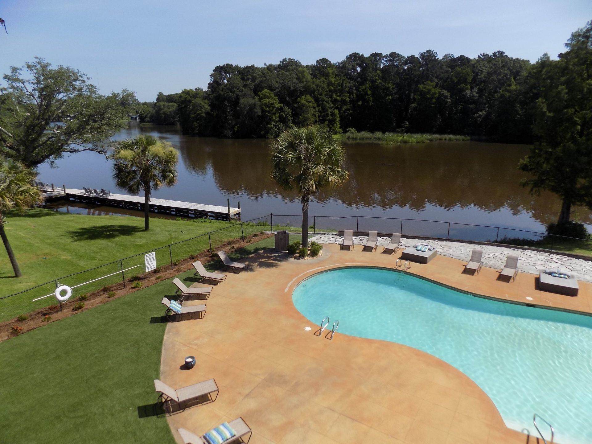 An aerial view of a large swimming pool with a lake in the background
